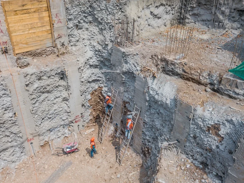 Excavación profunda con trabajadores y escaleras en una obra